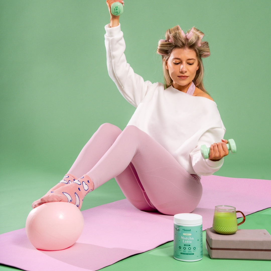 Creamy +boost Matcha Latte in a cup topped with frothy milk and vibrant green matcha powder, ready to enjoy.