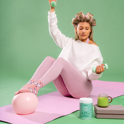 Creamy +boost Matcha Latte in a cup topped with frothy milk and vibrant green matcha powder, ready to enjoy.