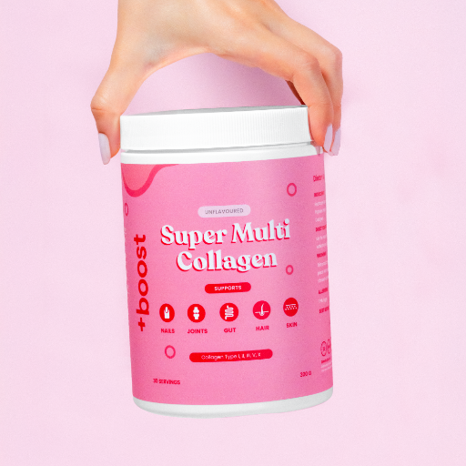 Pink container of Super Multi Collagen with a hand holding it against a pink background